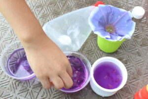 一年生が朝顔の花で色水を作って遊んでいるところ